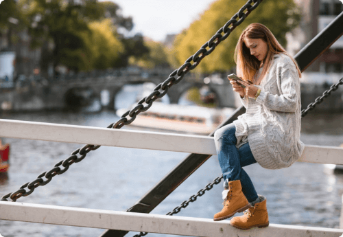 Vrouw zit op de brug en kijkt naar de vermogensbeheer kosten