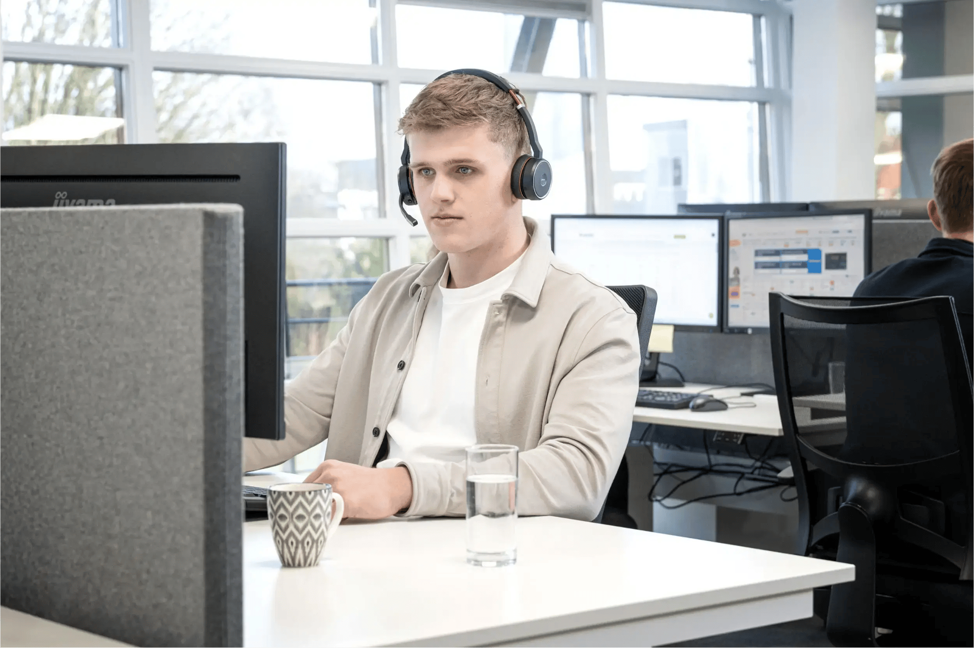 Medewerker bij Axento aan het bellen op kantoor zittend aan een bureau