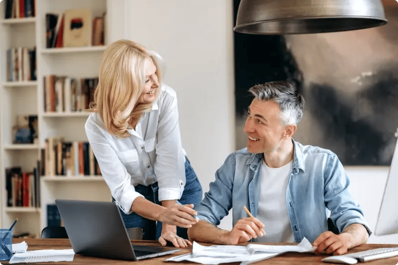 man en vrouw kijkend naar elkaar met tafel voor brieven en een laptop