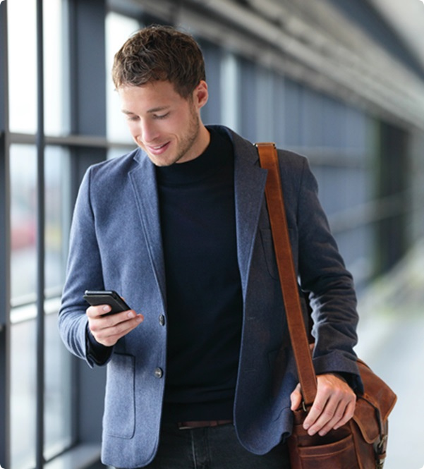 Jonge man kijkt naar zijn telefoon en heeft zelf toegang tot zijn geld