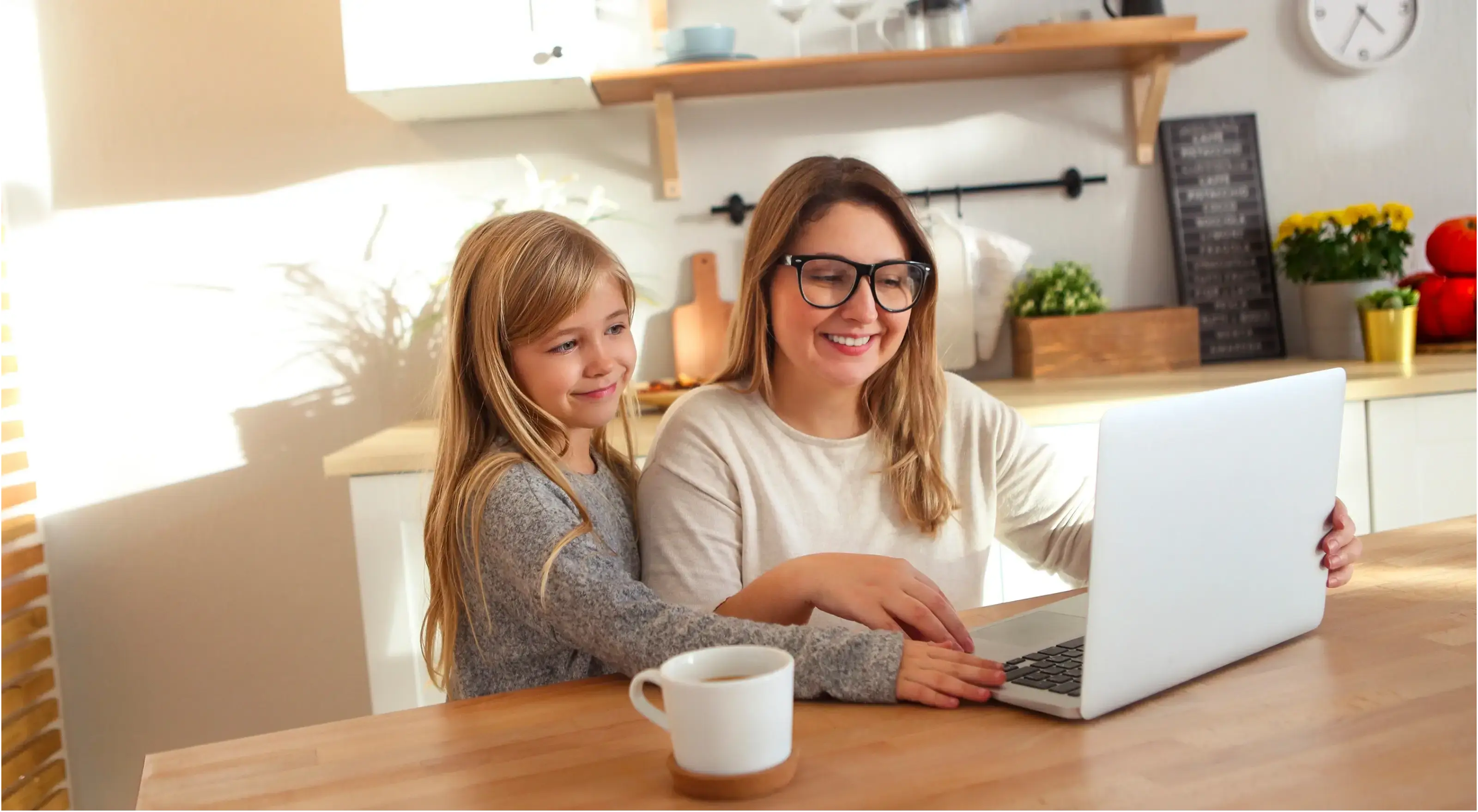 Moeder met klein meisje gebruiken laptop in de keuken
