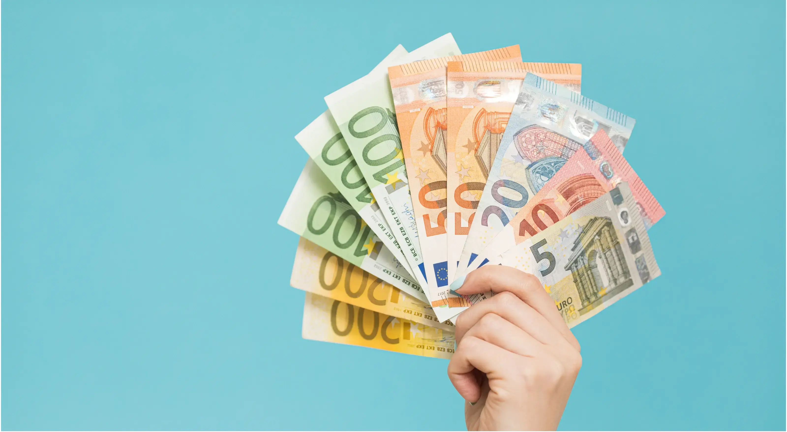 Close up van hand die briefjes van 5, 10, 20, 50, 100 en 200 euro's vasthoudt