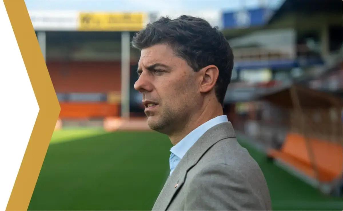 Kees Kwakman staat langs de zijlijn in een voetbalstadion