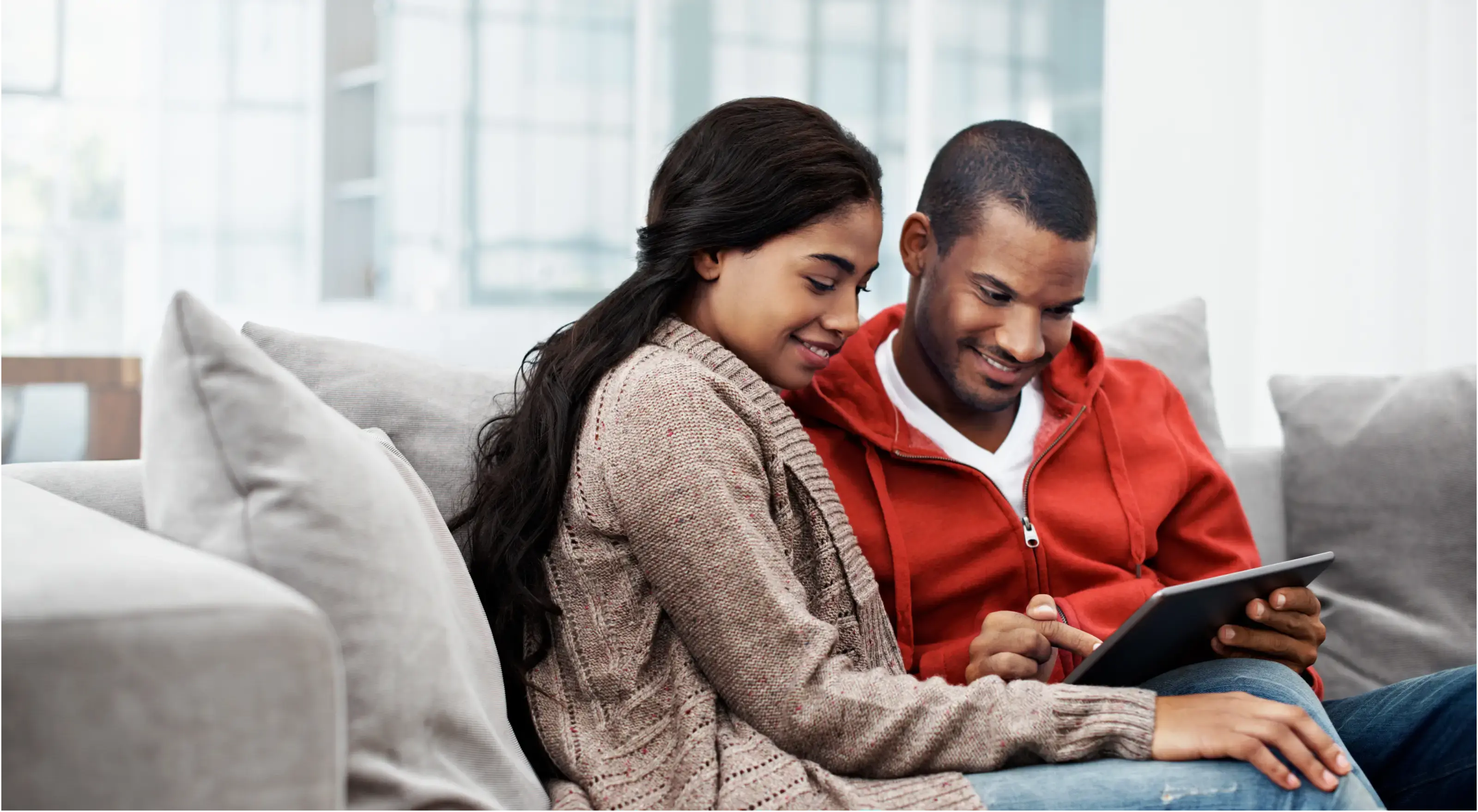 Man en vrouw zitten op de bank en vullen een online vragenlijst in, omdat ze willen beginnen met beleggen.