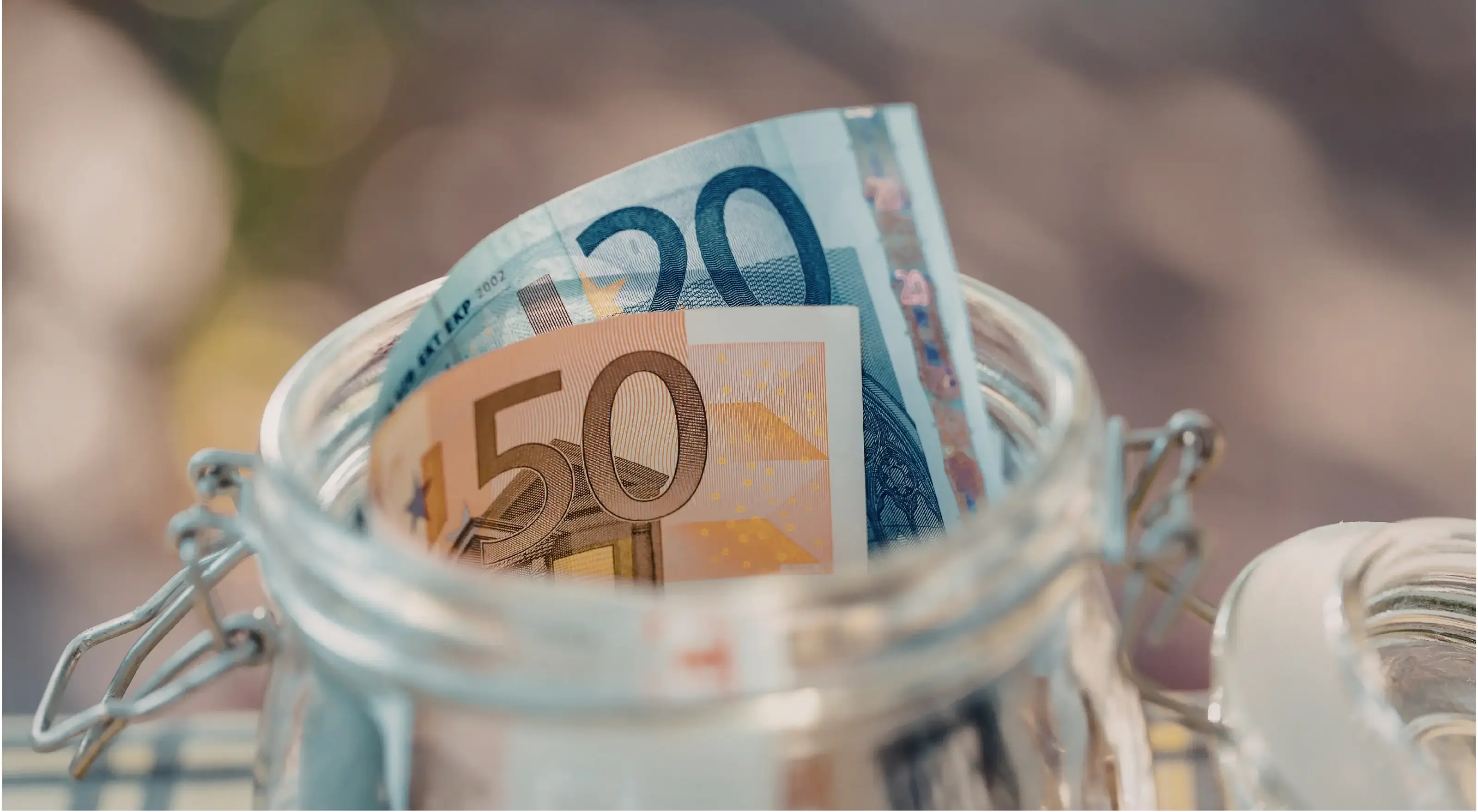Briefjes van 50 euro en 20 euro in een glazen potje