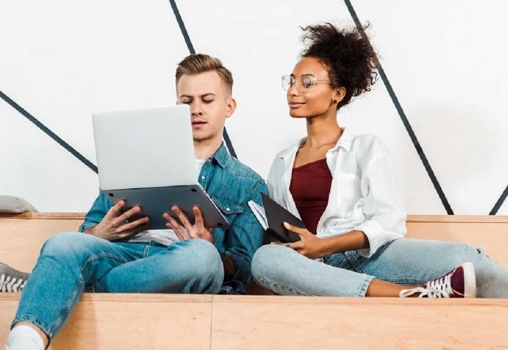 Man en vrouw die zitten en kijken naar een laptop.