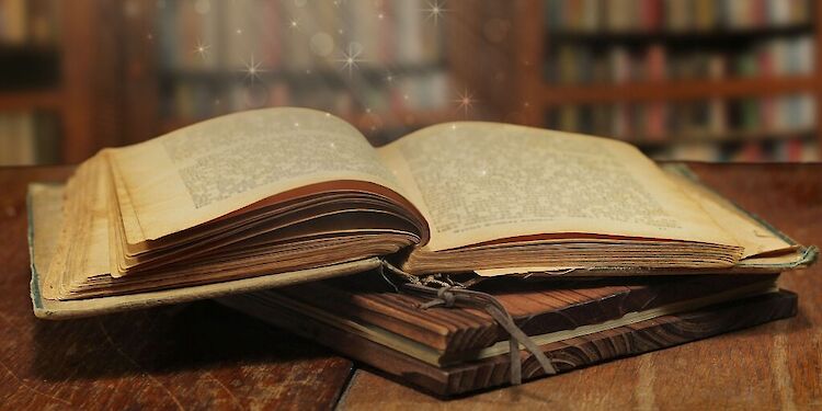 Opengeslagen oud boek op een houten tafel